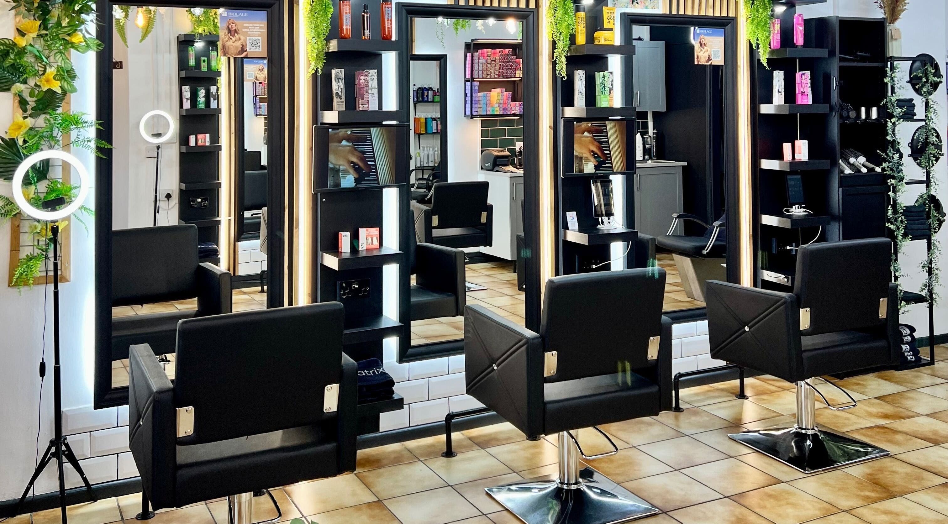 Modern salon interior at The Hair Lounge Bulwark Road, Chepstow, Wales, GB with sleek black chairs and mirrors.