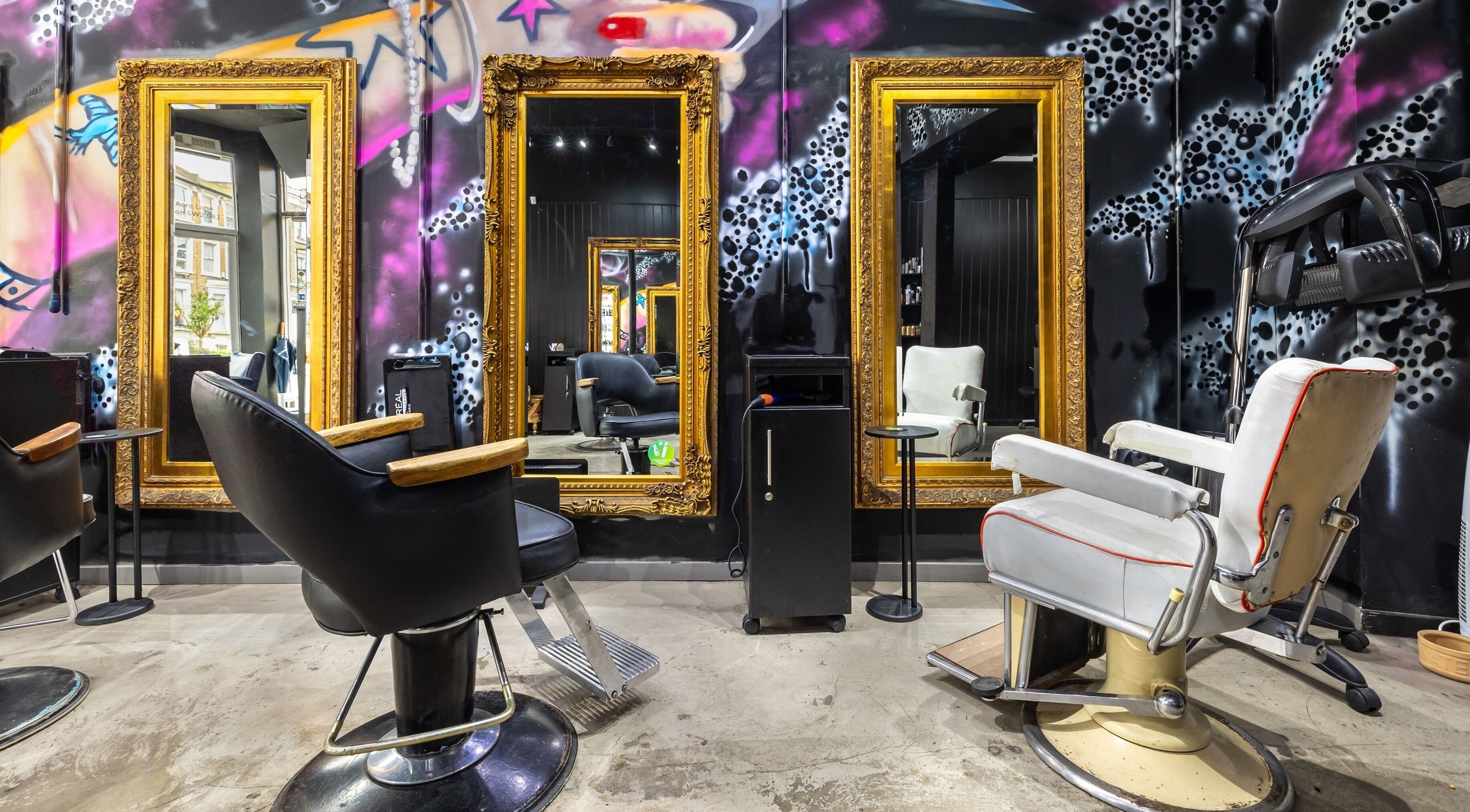 Stylish hair salon interior at Love Hair Brixton, London, England, GB, featuring ornate mirrors and chic chairs.