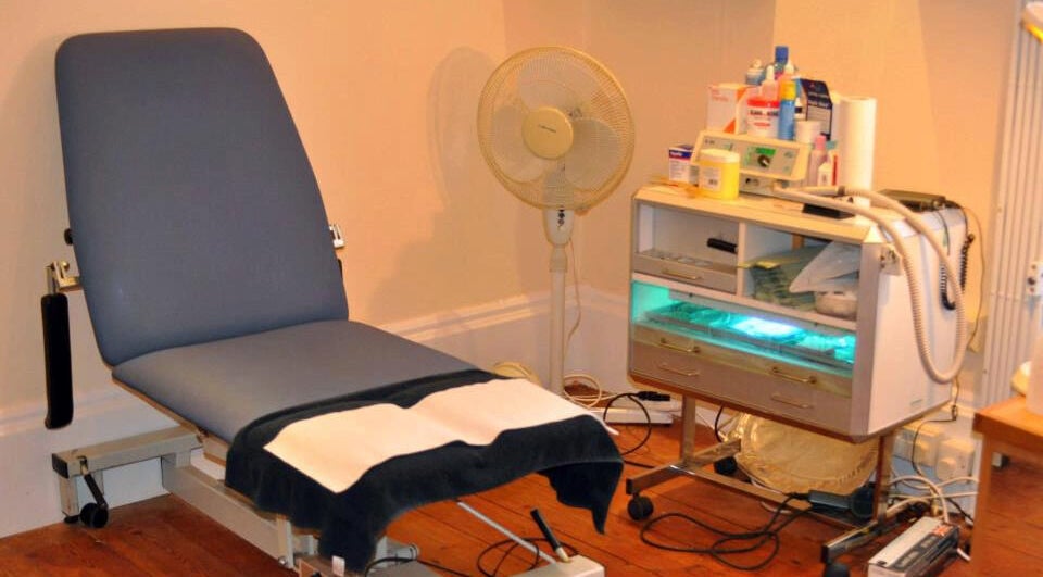 Treatment room at Pods Footcare Specialists with chair and equipment in Beccles, England, GB.