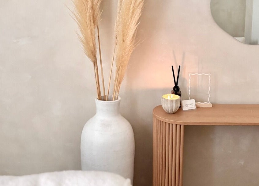 Angel Lash lounge area in Beaconsfield, Western Australia with vase, candle, and mirror for relaxation.