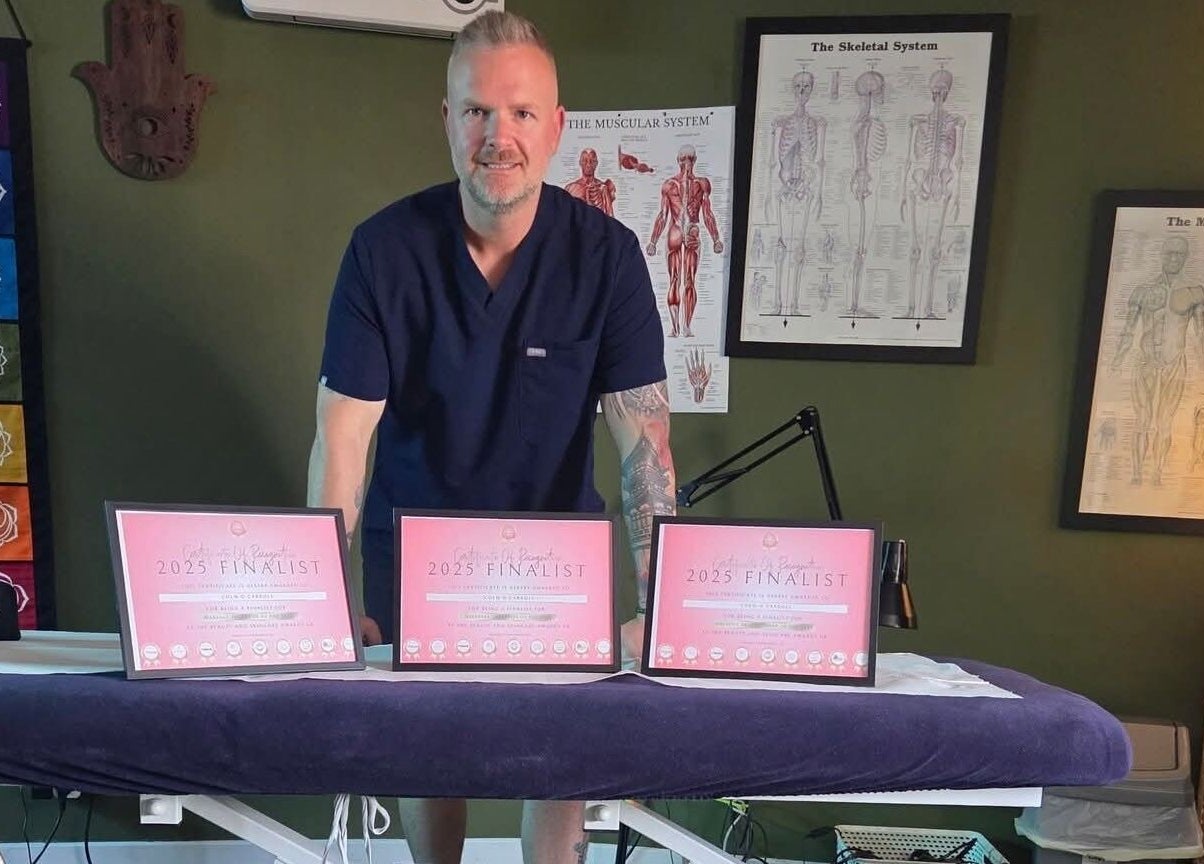 Award-winning therapist at Macroom Massage and Holistic Clinic, County Cork, IE, with certificates displayed.