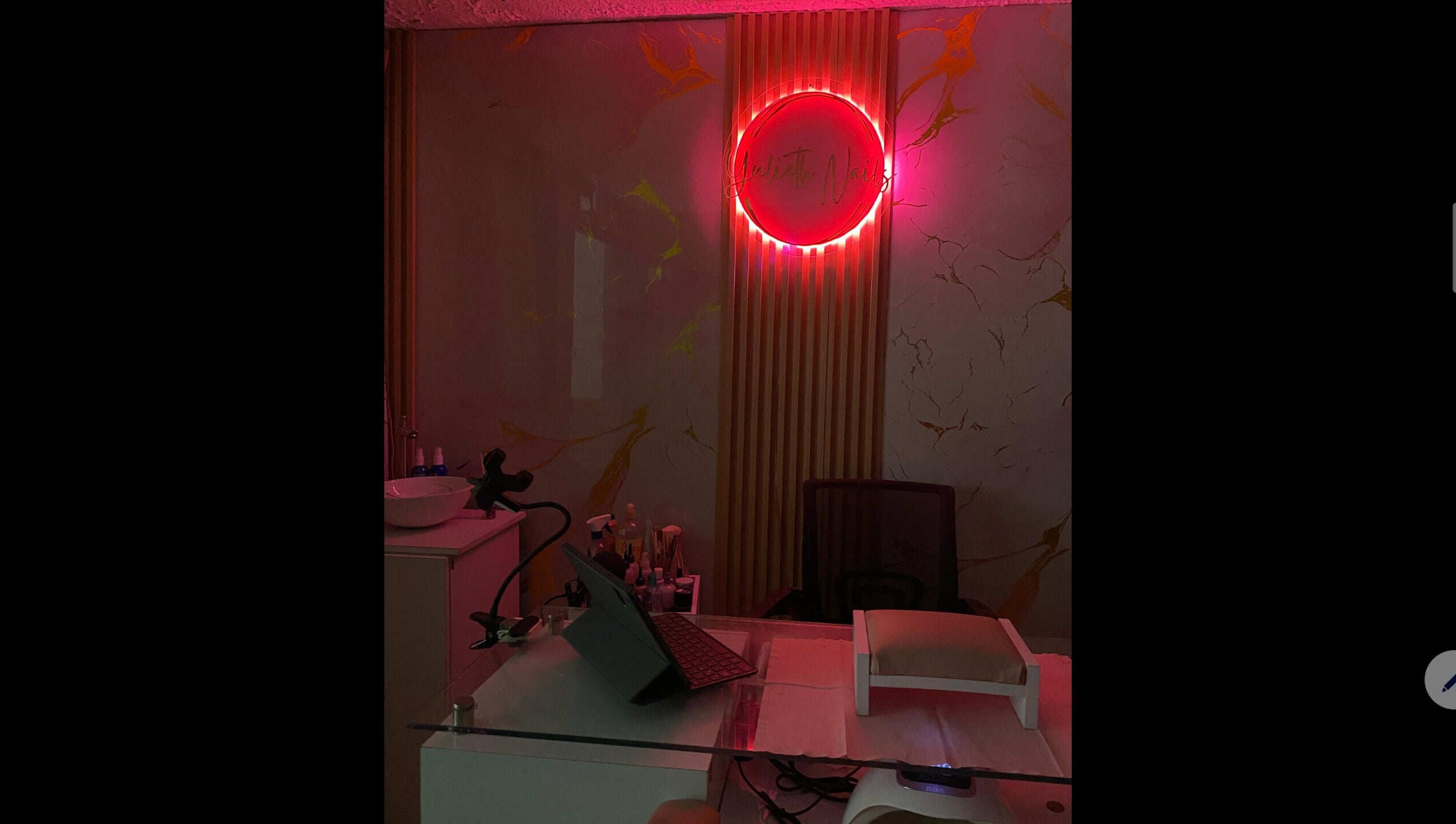 Área de manicura en Yulieth Nails, Buenaventura, Valle del Cauca, CO con luz ambiental rosa.