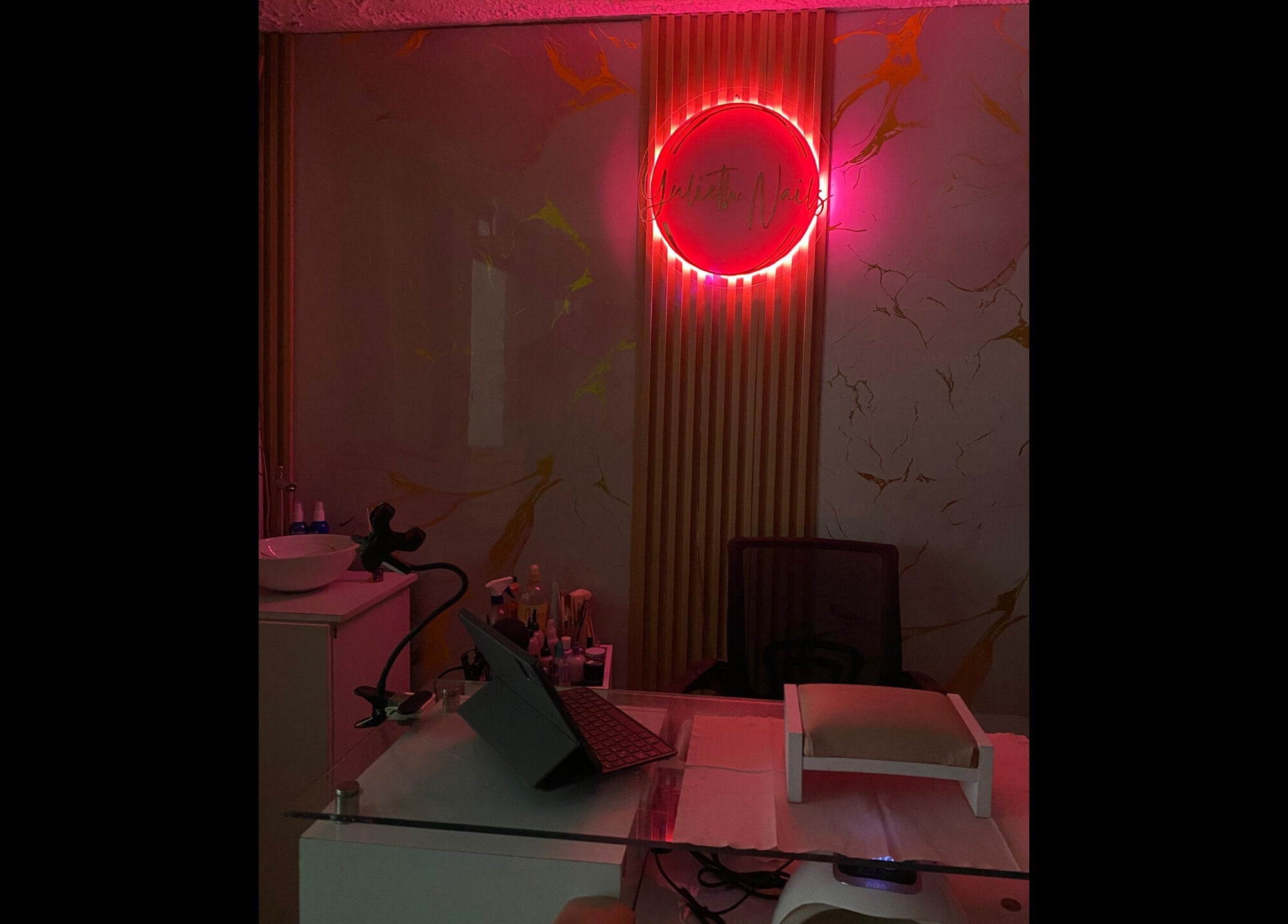 Área de manicura en Yulieth Nails, Buenaventura, Valle del Cauca, CO con luz ambiental rosa.