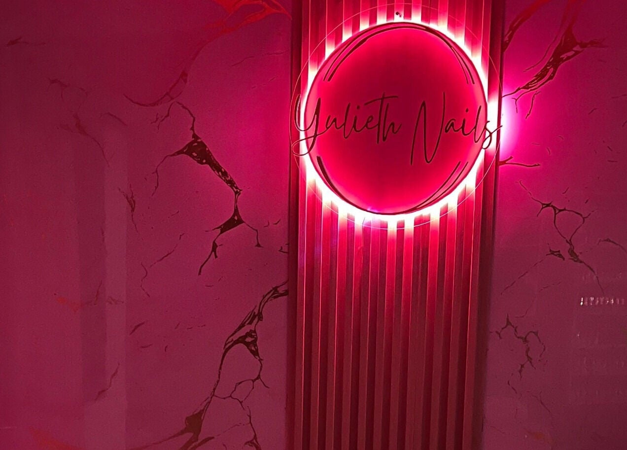 Letrero de neón rosa en Yulieth Nails, Buenaventura, Valle del Cauca, CO, creando un ambiente moderno y acogedor.