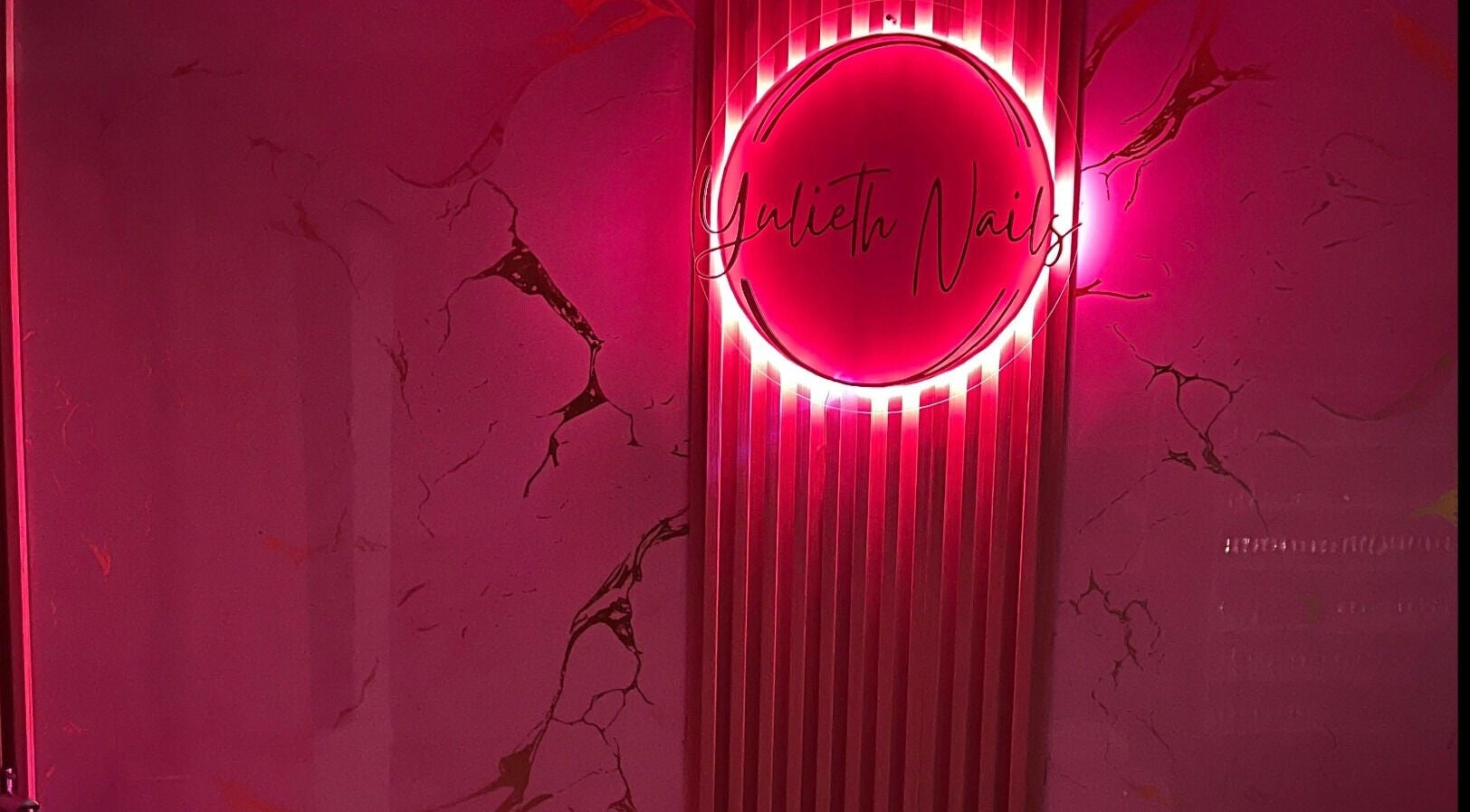 Letrero de neón rosa en Yulieth Nails, Buenaventura, Valle del Cauca, CO, creando un ambiente moderno y acogedor.