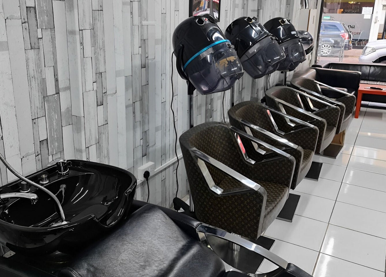Stylish seating at Adiscolocstylist in Peckham, United Kingdom, GB, featuring modern salon chairs and washbasin.