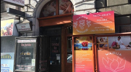 Front of Wairua Thai Masszazs Szalon in Budapest, Magyar, HU with colorful signage and massage images.