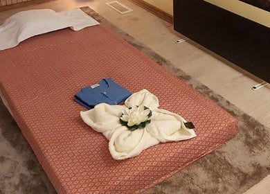 Peaceful massage room at Wairua Thai Masszazs Szalon, Budapest, Magyar, HU with a neatly made bed.