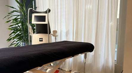 A serene treatment room at Saunapod, Falmouth, England, GB, featuring an LPG machine and a comfortable treatment bed.