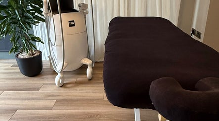 Saunapod wellness room in Falmouth, England, GB with black massage table and modern equipment.