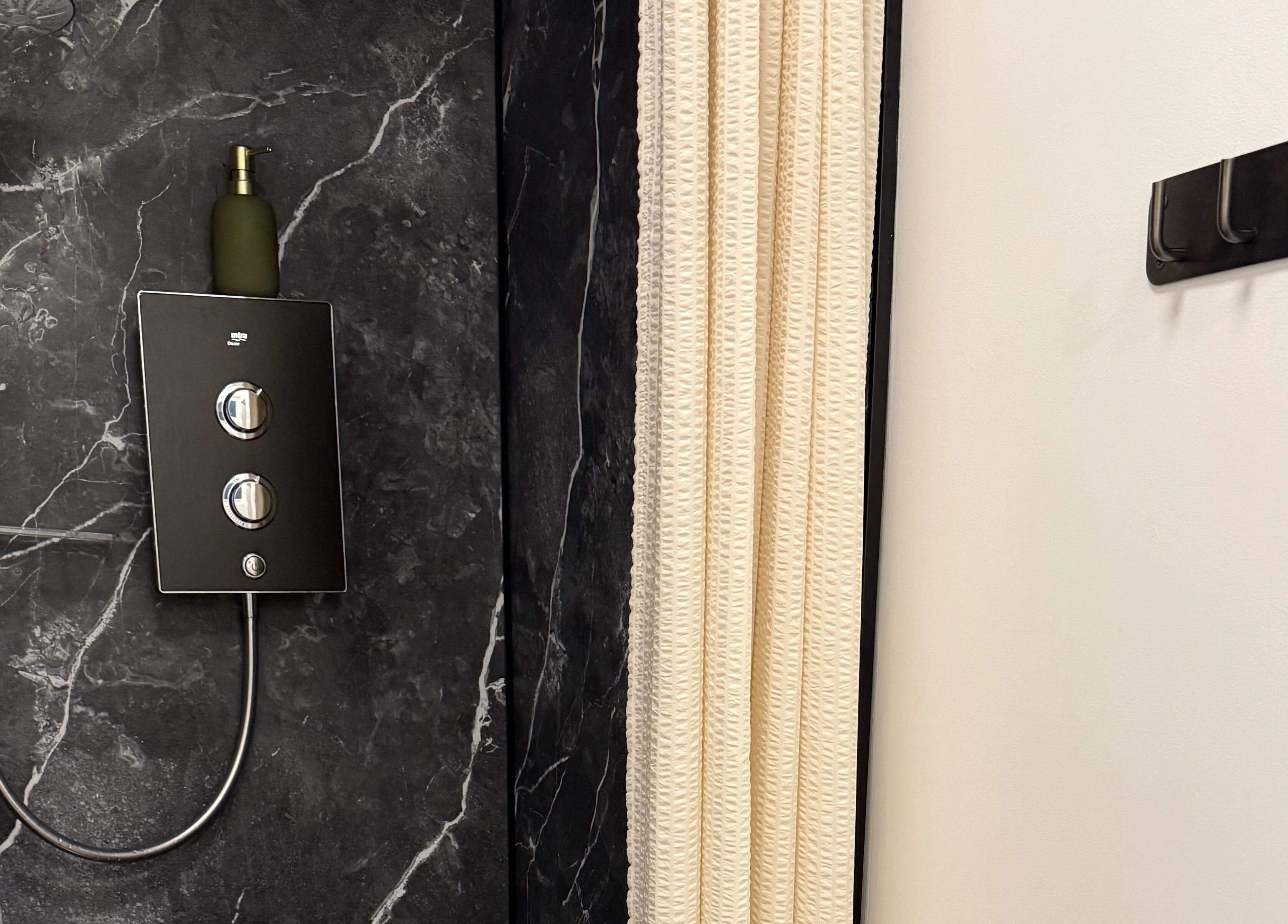 Modern shower panel with marble wall detail in Saunapod, Falmouth, England, GB for a luxury experience.