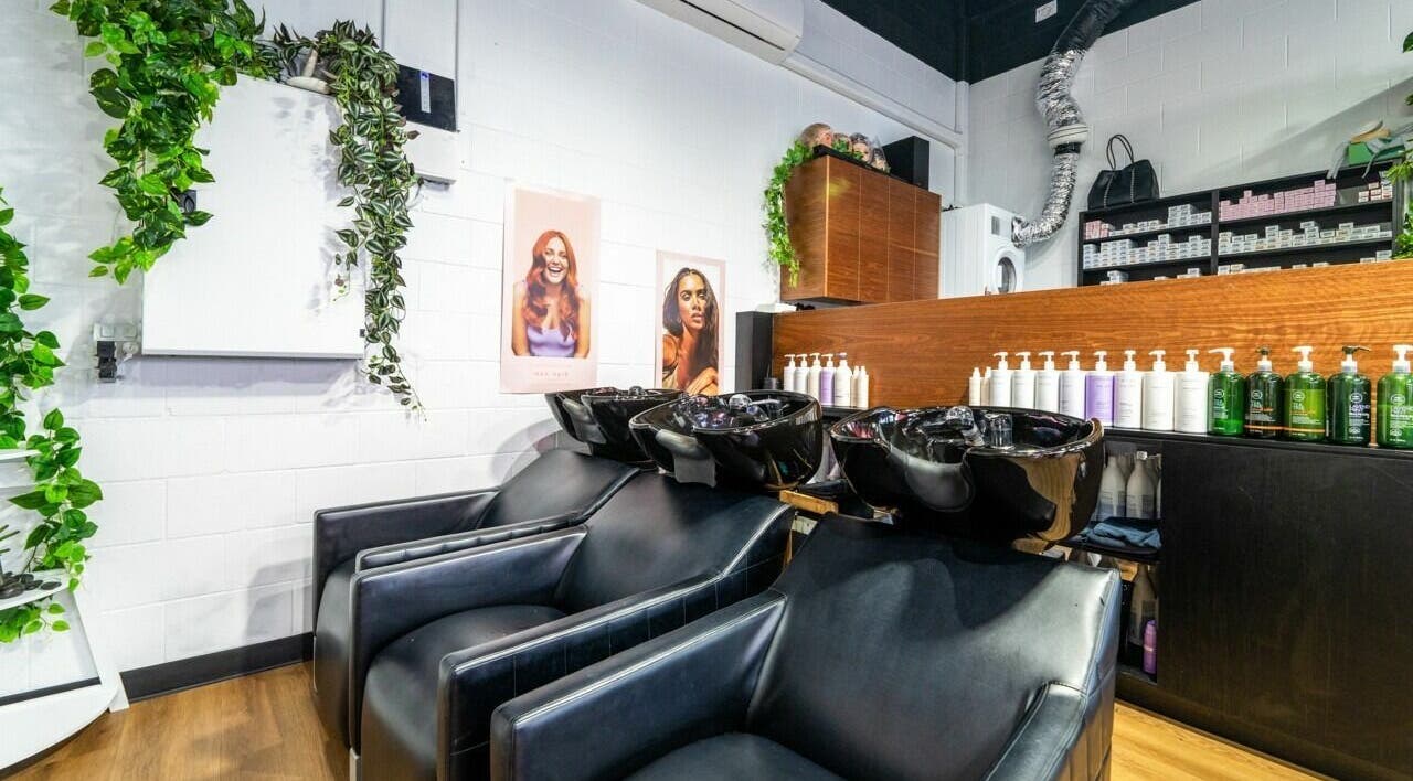 Modern salon interior at AW Hair Studios - Broadbeach, Broadbeach, Queensland, AU, showcasing wash stations and products.