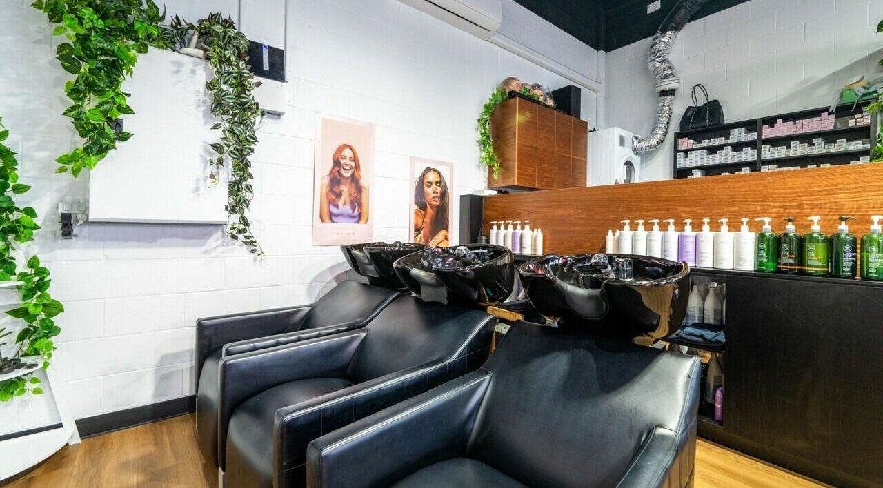 Modern salon interior at AW Hair Studios - Broadbeach, Broadbeach, Queensland, AU, showcasing wash stations and products.
