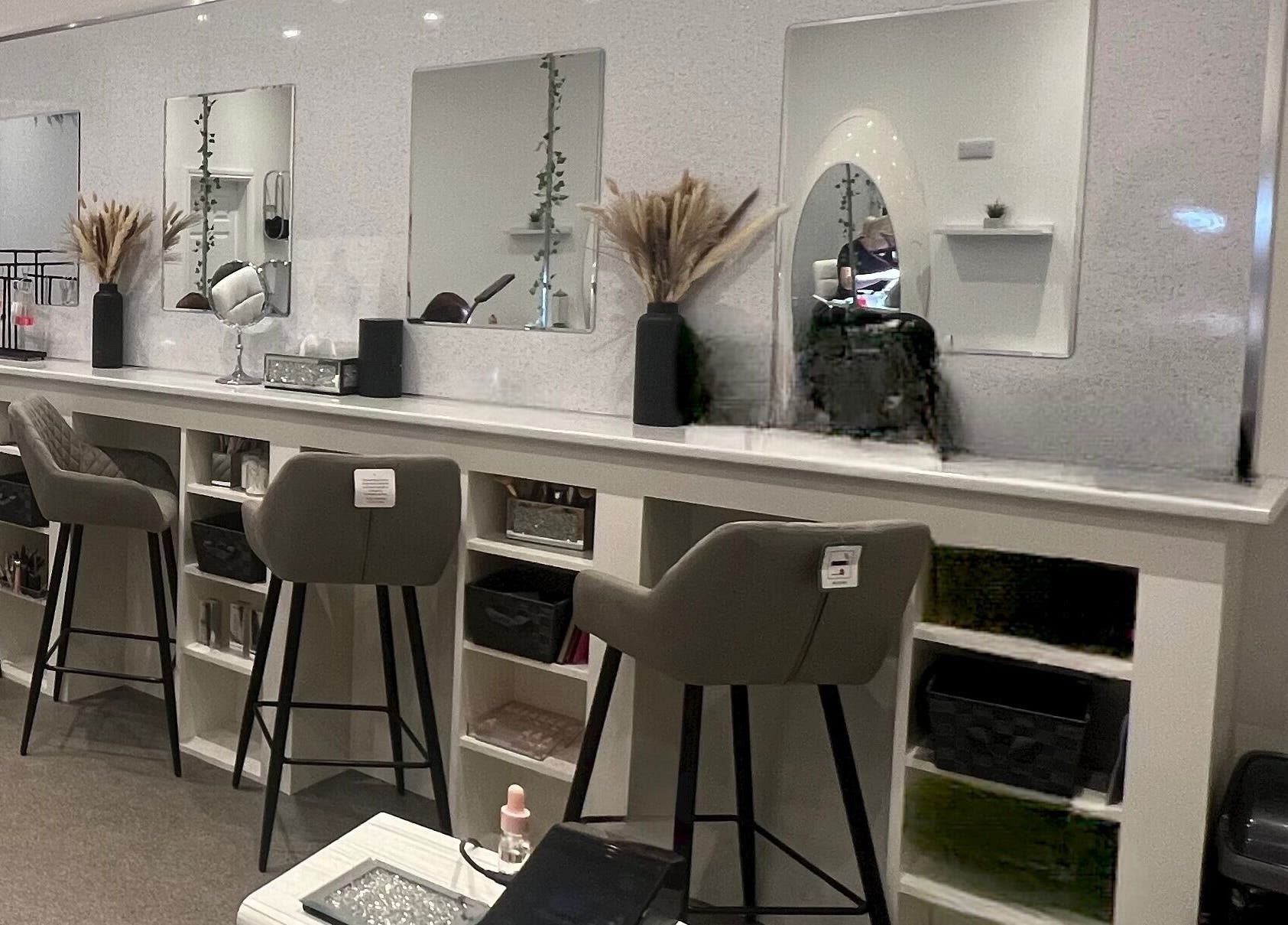 Chic beauty stations at Elysium Beauty Limited, Castletown, GB, featuring stylish mirrors and plush seating.