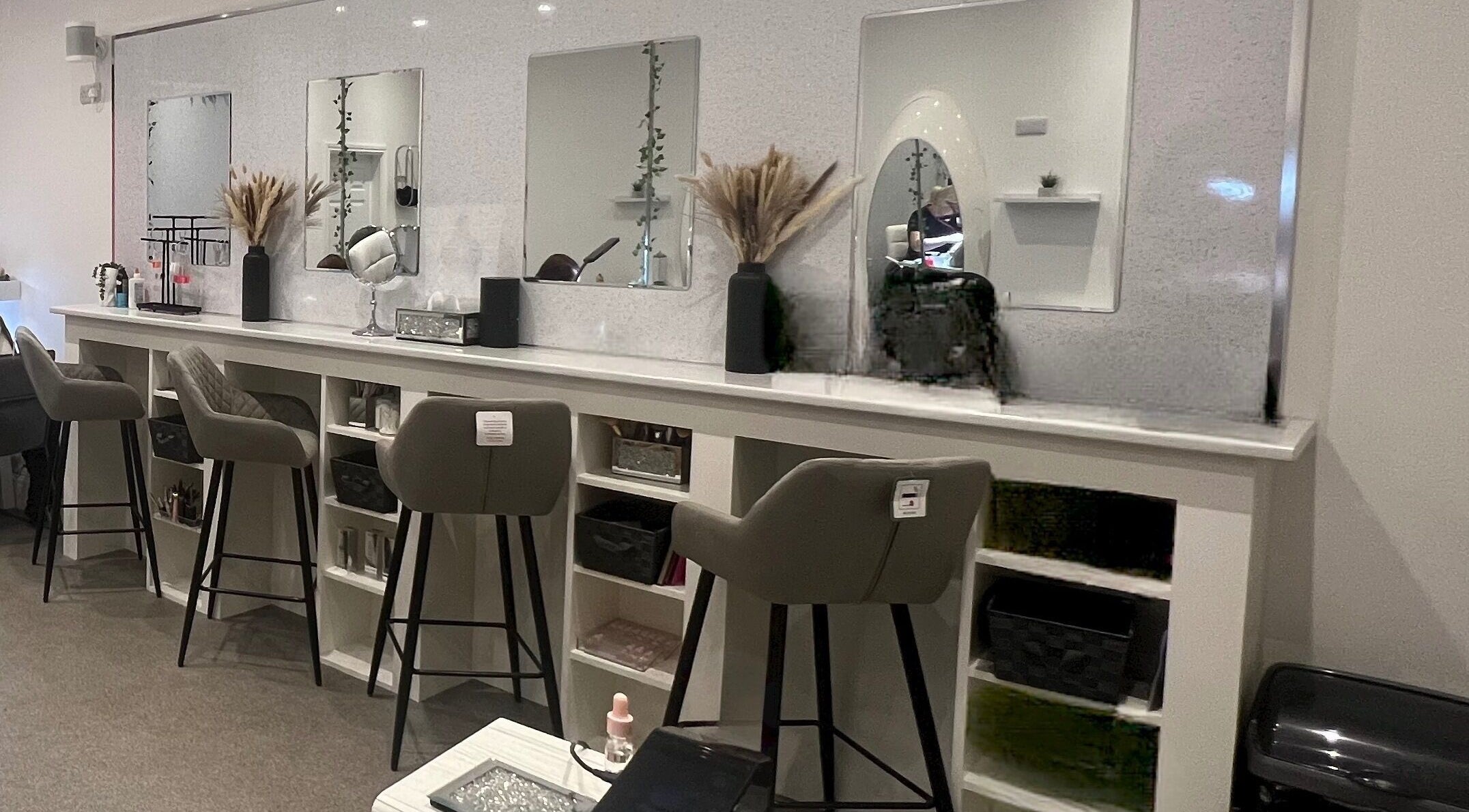Chic beauty stations at Elysium Beauty Limited, Castletown, GB, featuring stylish mirrors and plush seating.