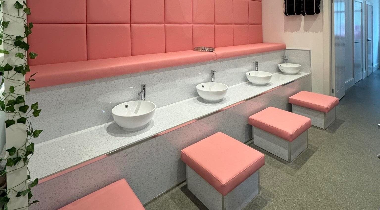 Stylish wash area with pink seating at Elysium Beauty Limited in Castletown, GB.