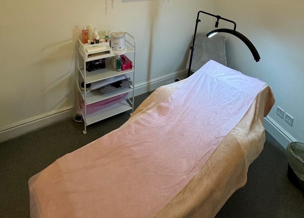 Tranquil treatment room at Elysium Beauty Limited, Castletown, GB, featuring a soft pink therapy bed and essentials.