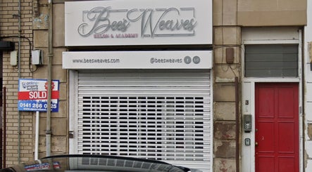 Front view of bees. salon in Paisley, Scotland, GB with a closed shutter and a sign above.