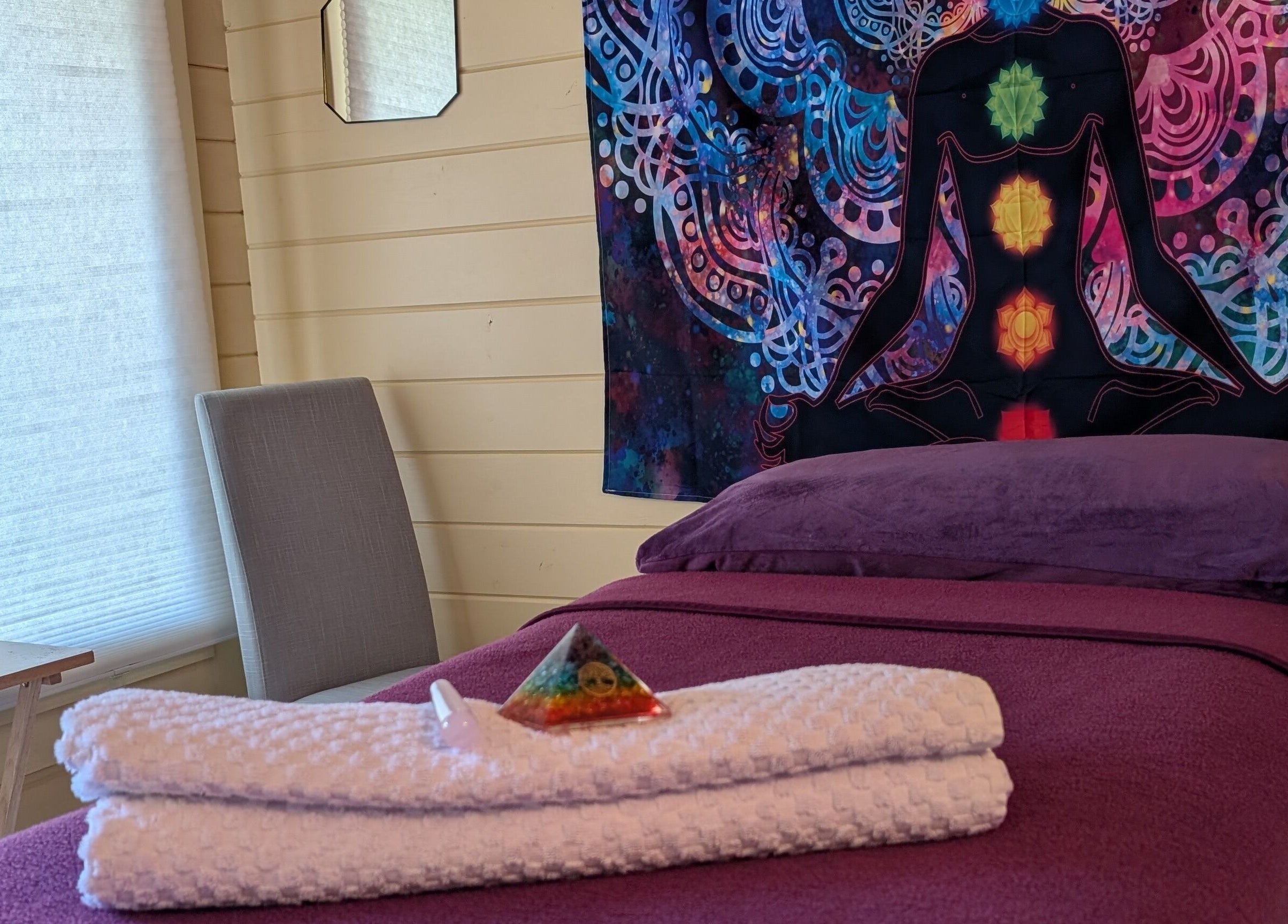 Meditative room at The Holistic Hideaway, Saint Neots, England, GB with chakra tapestry and massage table.