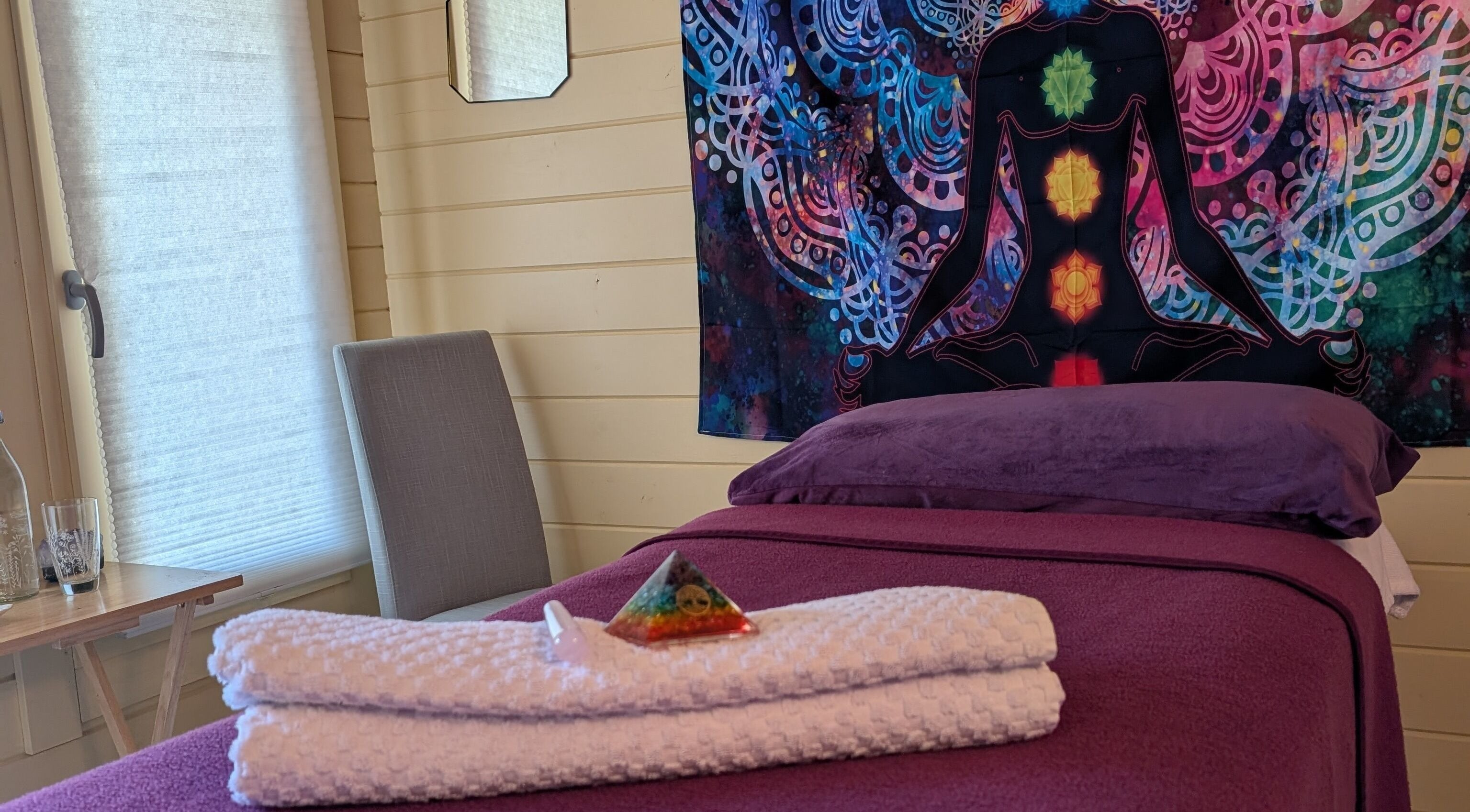 Meditative room at The Holistic Hideaway, Saint Neots, England, GB with chakra tapestry and massage table.