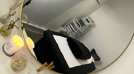 Elegant treatment room at Derma, Glasgow, Scotland, GB with cozy black bed, mirror, and ambient lighting.
