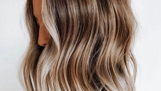 Glossy wavy blonde hair at STORI, Birmingham, England, GB. Perfectly styled for a chic look.