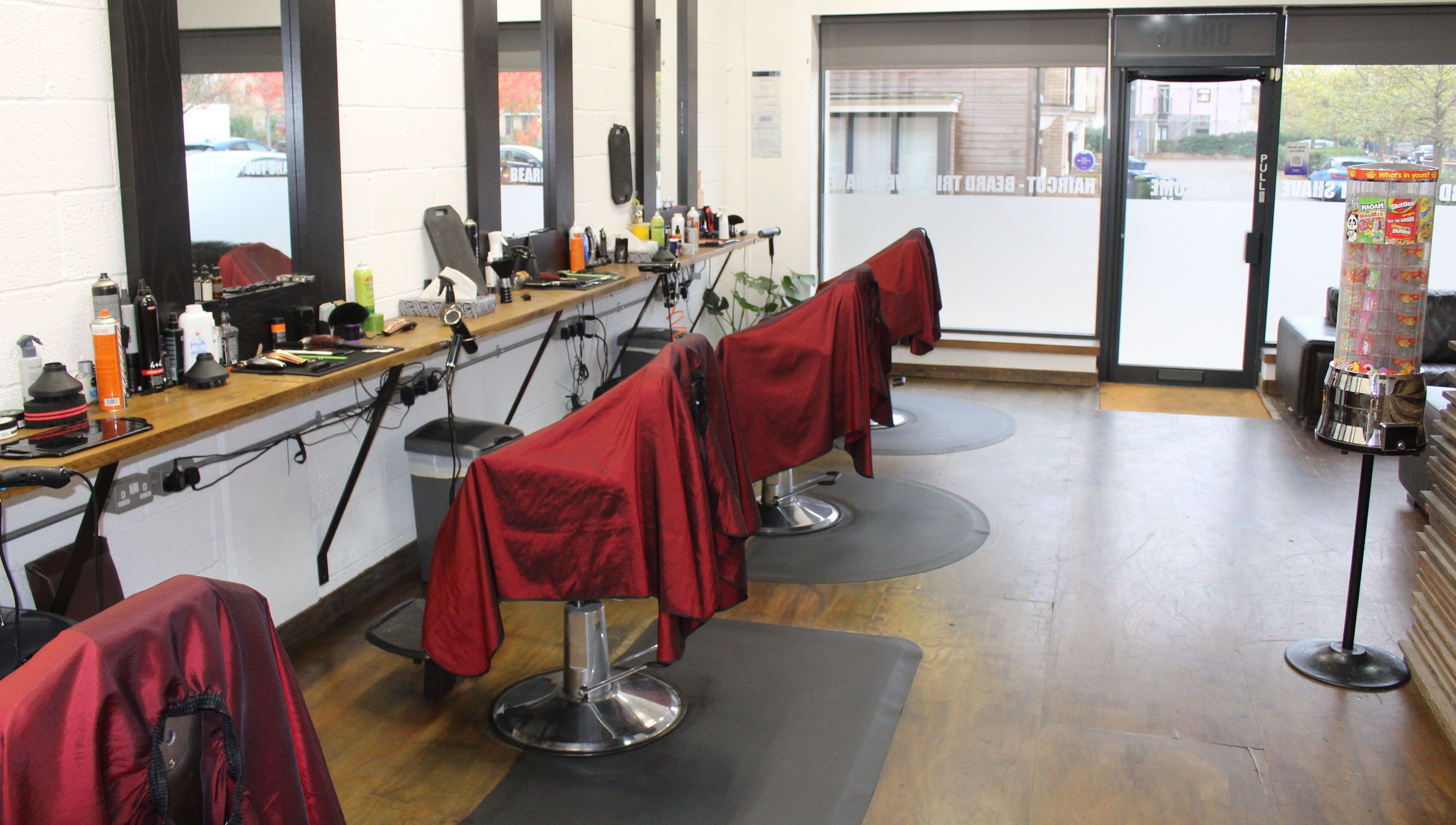 Modern barber chairs lined up at Lewis' Barbershop in Cambridge, England, GB with stylish interior setup.