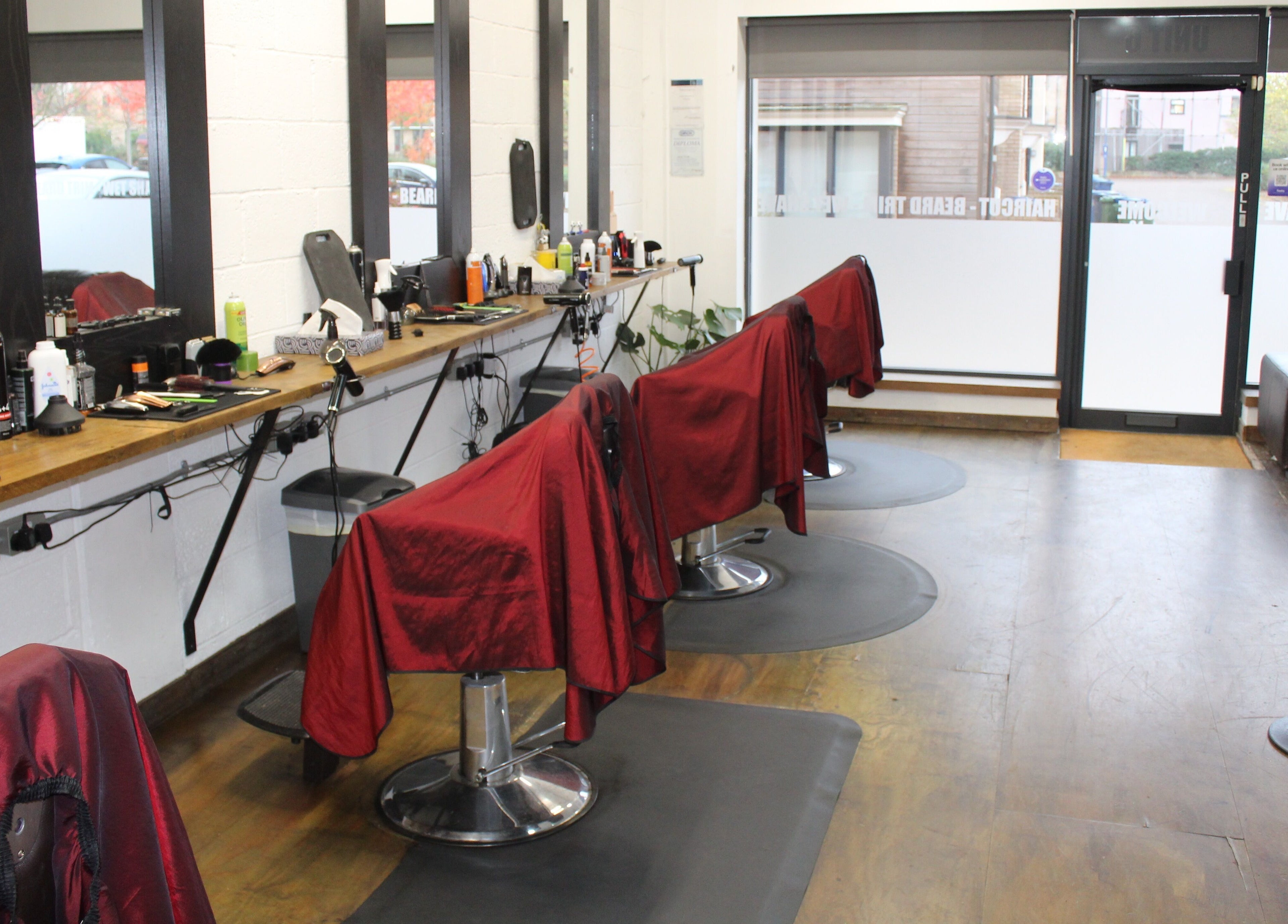 Modern barber chairs lined up at Lewis' Barbershop in Cambridge, England, GB with stylish interior setup.