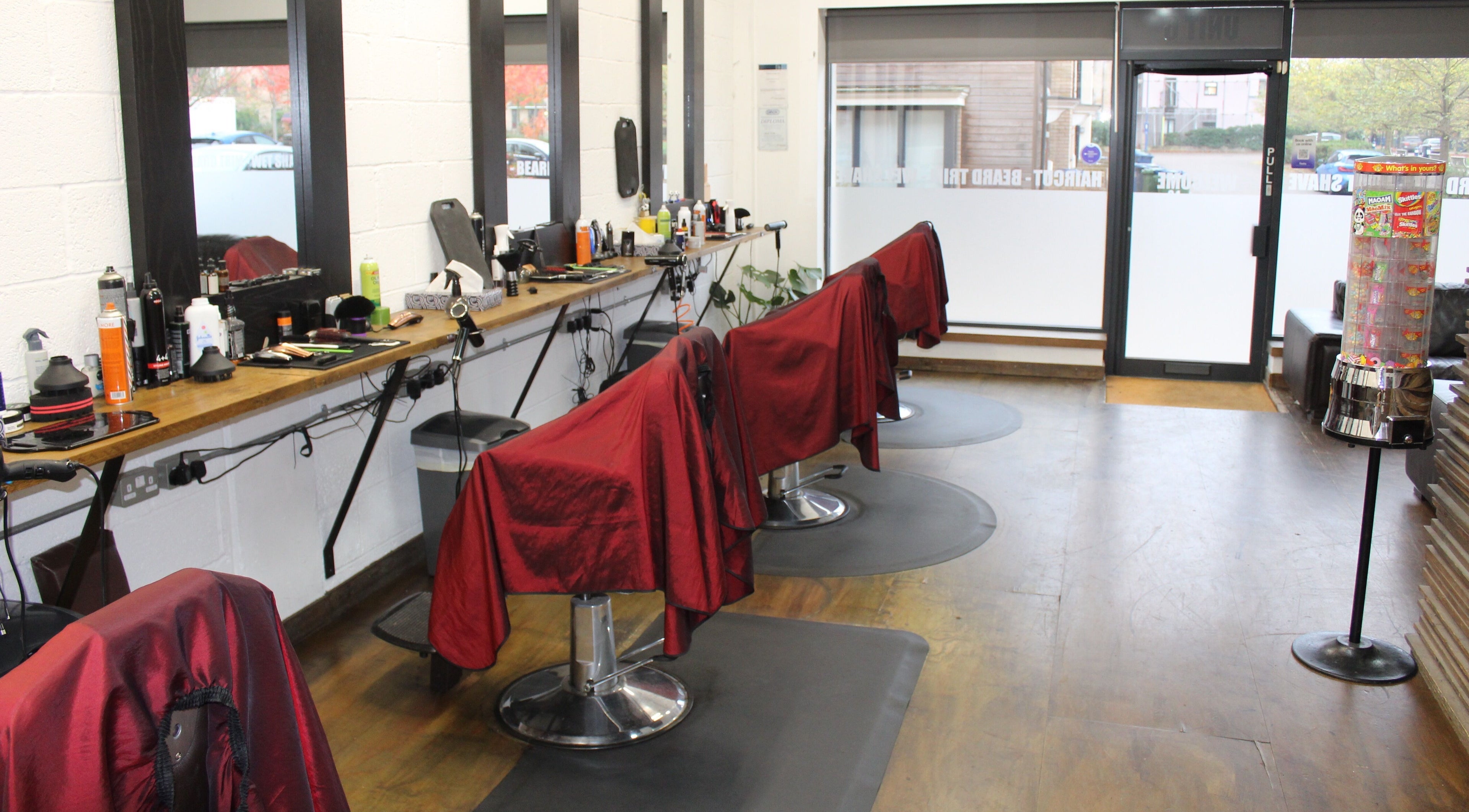 Modern barber chairs lined up at Lewis' Barbershop in Cambridge, England, GB with stylish interior setup.
