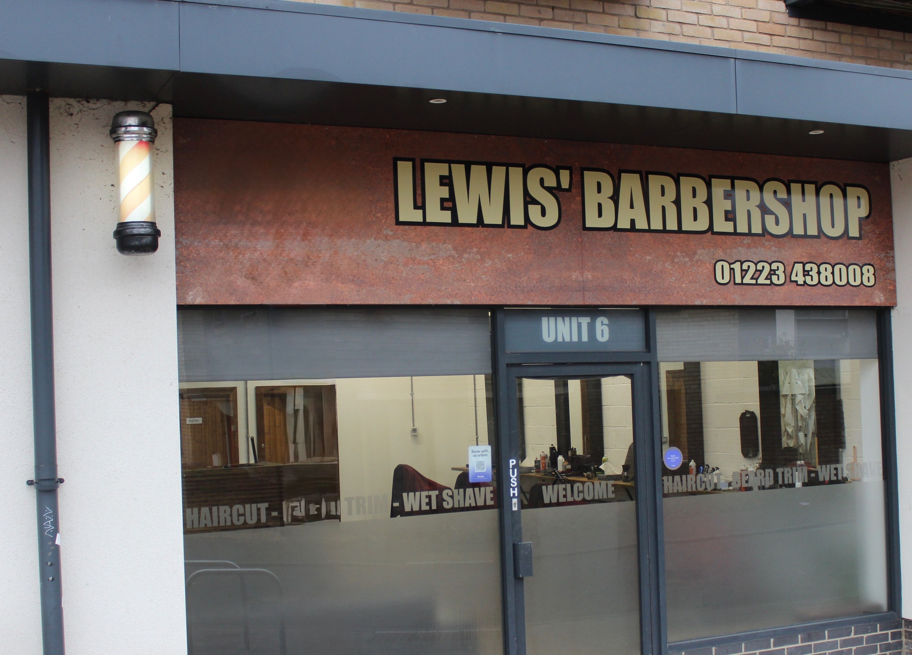 Front view of Lewis' Barbershop in Cambridge, England, GB, featuring classic signage.