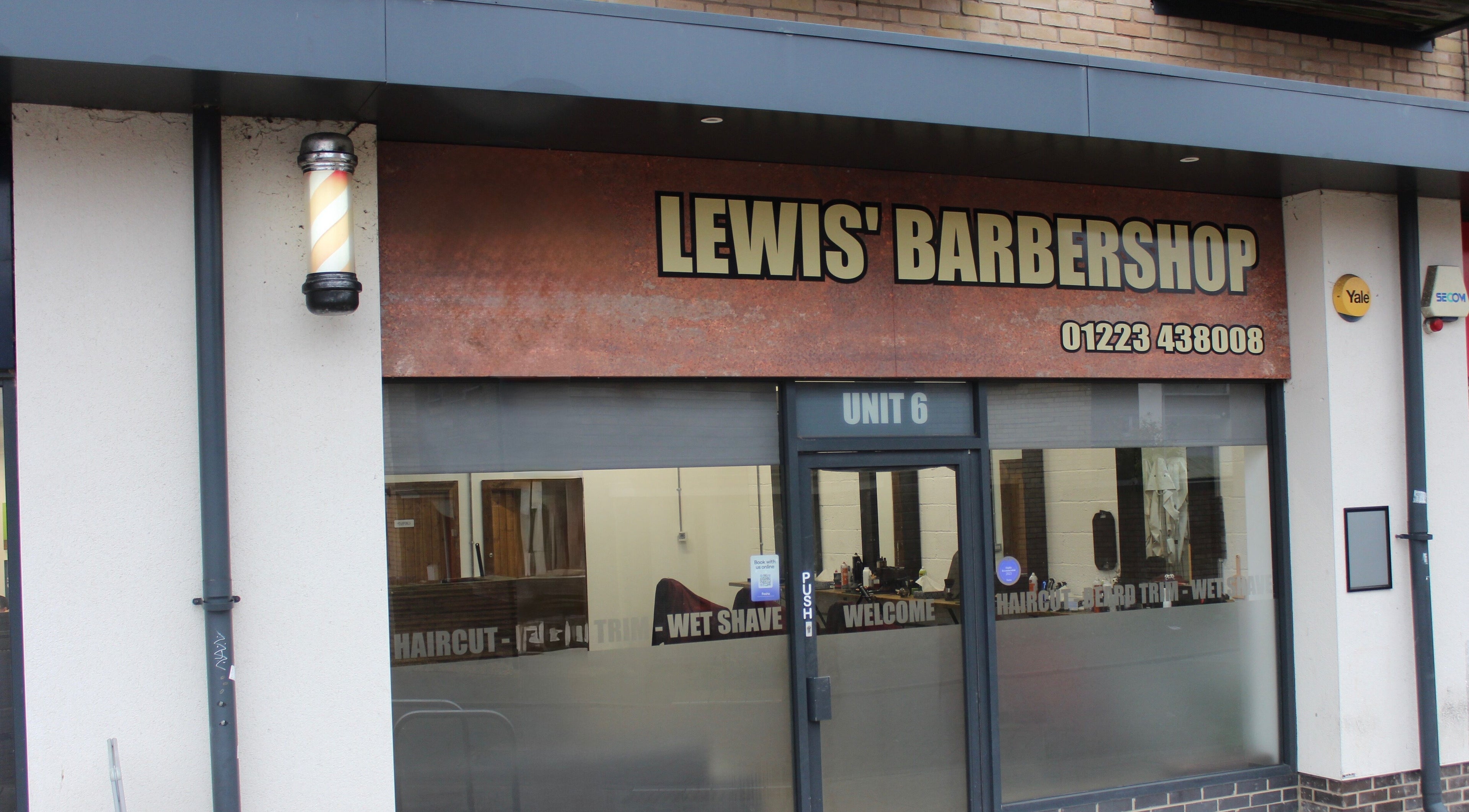 Front view of Lewis' Barbershop in Cambridge, England, GB, featuring classic signage.