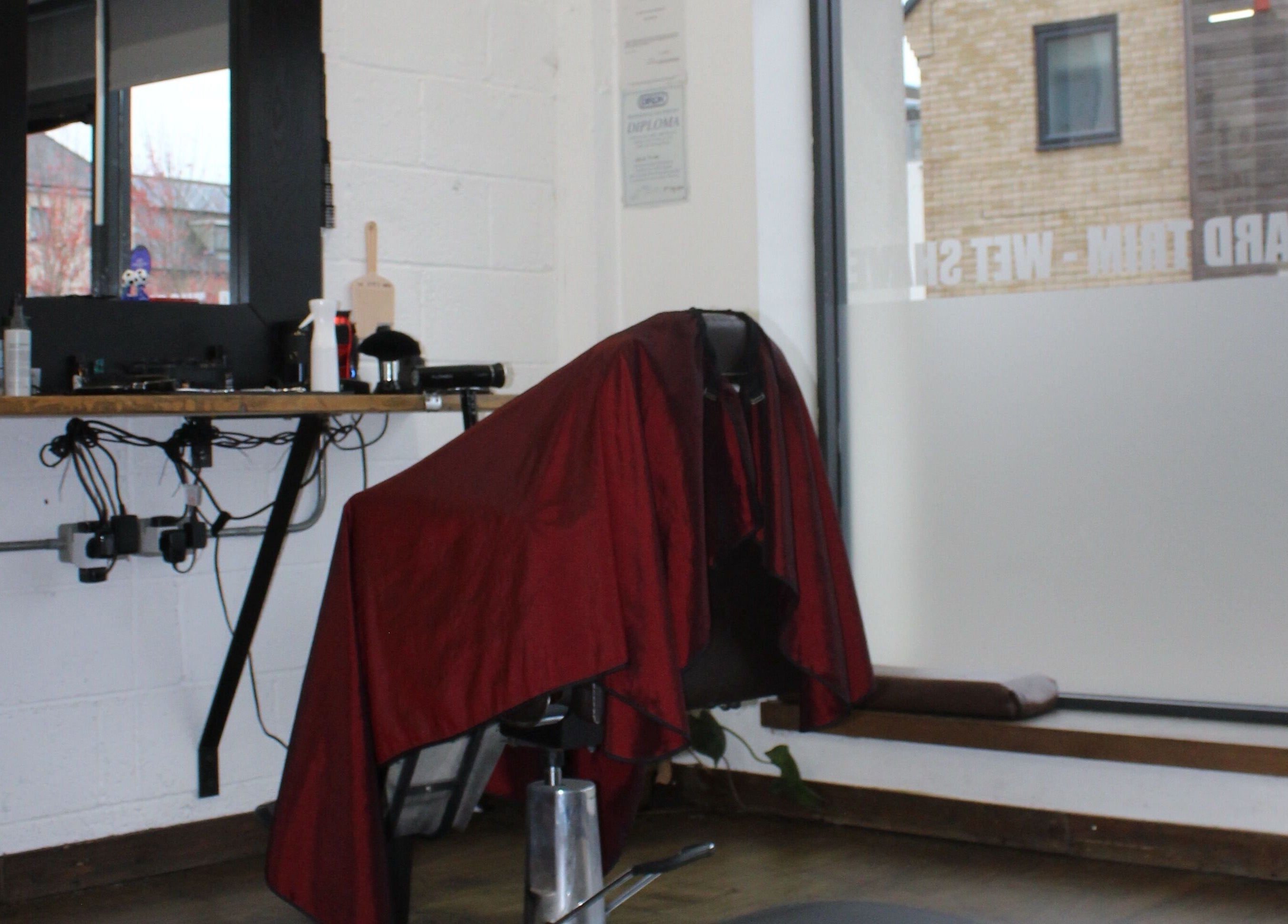 Cozy interior of Lewis' Barbershop, Cambridge, England, GB showcasing barber chair and styling tools.