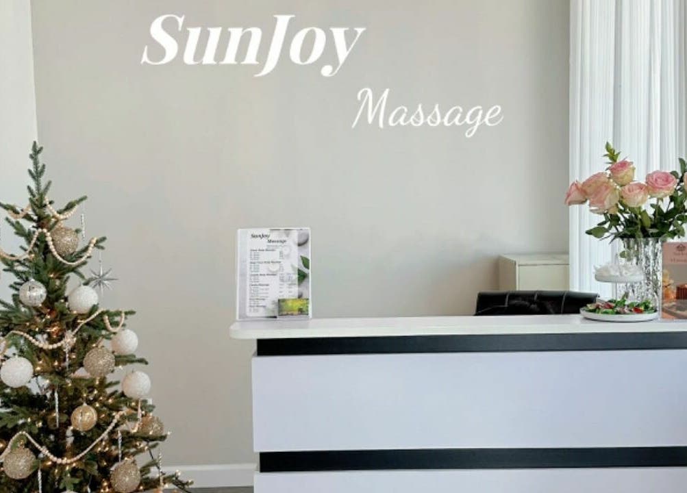 Reception area at Sun Joy Massage Spa in Wichita, Kansas, US with festive decor and flowers.