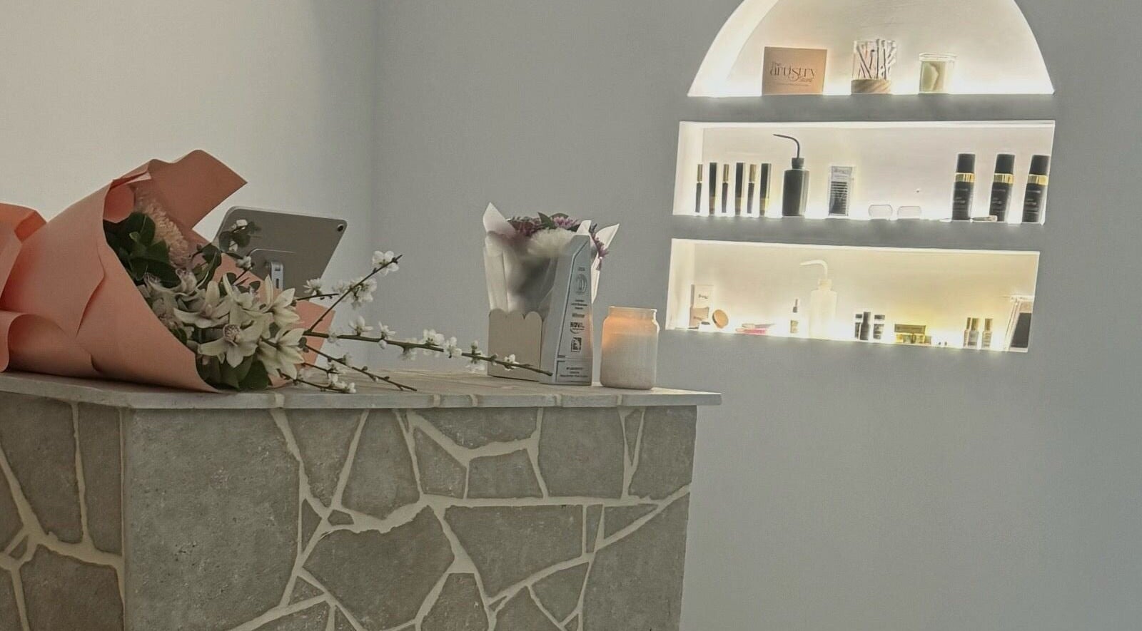 Chic reception at MP Lash Artistry, Narellan, New South Wales, AU with stylish stone counter and beauty products.