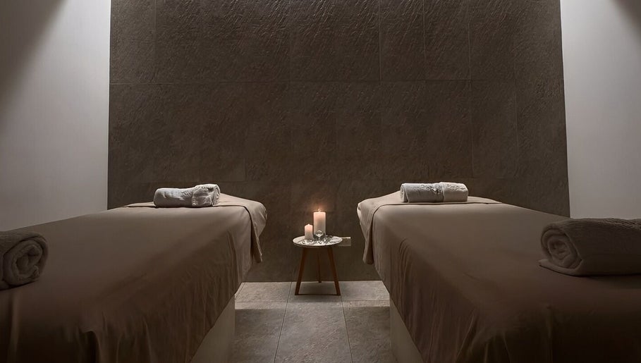 Tranquil massage room at Le Spa Noir, Medellín, Antioquia, CO, featuring two tables and ambient candlelight.