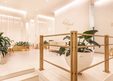 Elegant entry of Le Spa Noir in Medellín, Antioquia, CO, featuring plush seats and lush plants.