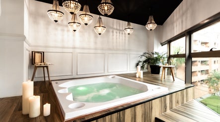 Elegant spa room with hot tub at Le Spa Noir, Medellín, Antioquia, CO. Luxurious chandeliers and candles.