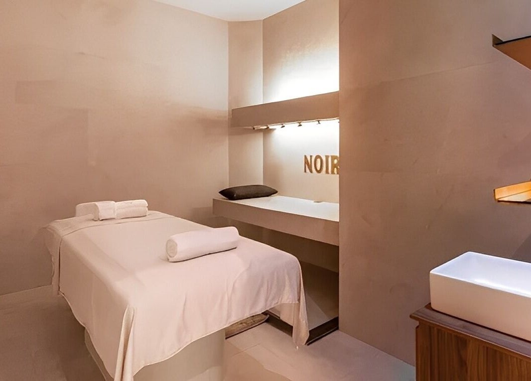 Tranquil massage room at Le Spa Noir in Medellín, Antioquia, CO, featuring a plush treatment bed and ambient lighting.
