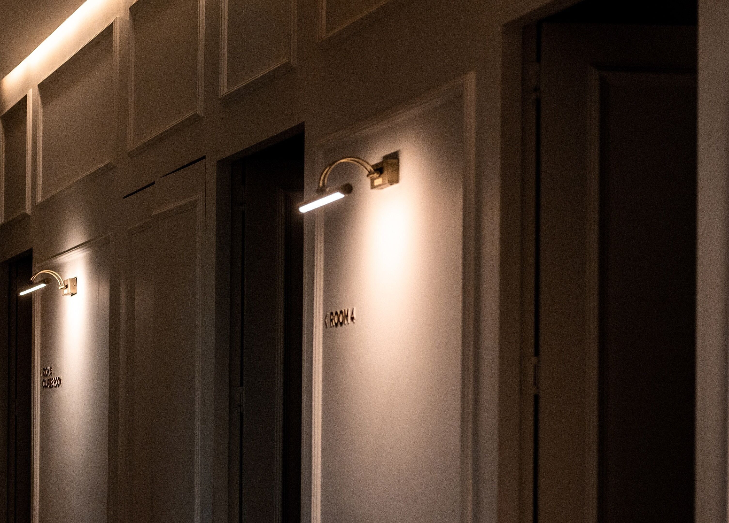 Dimly lit corridor with wall lights at Le Spa Noir in Medellín, Antioquia, CO.