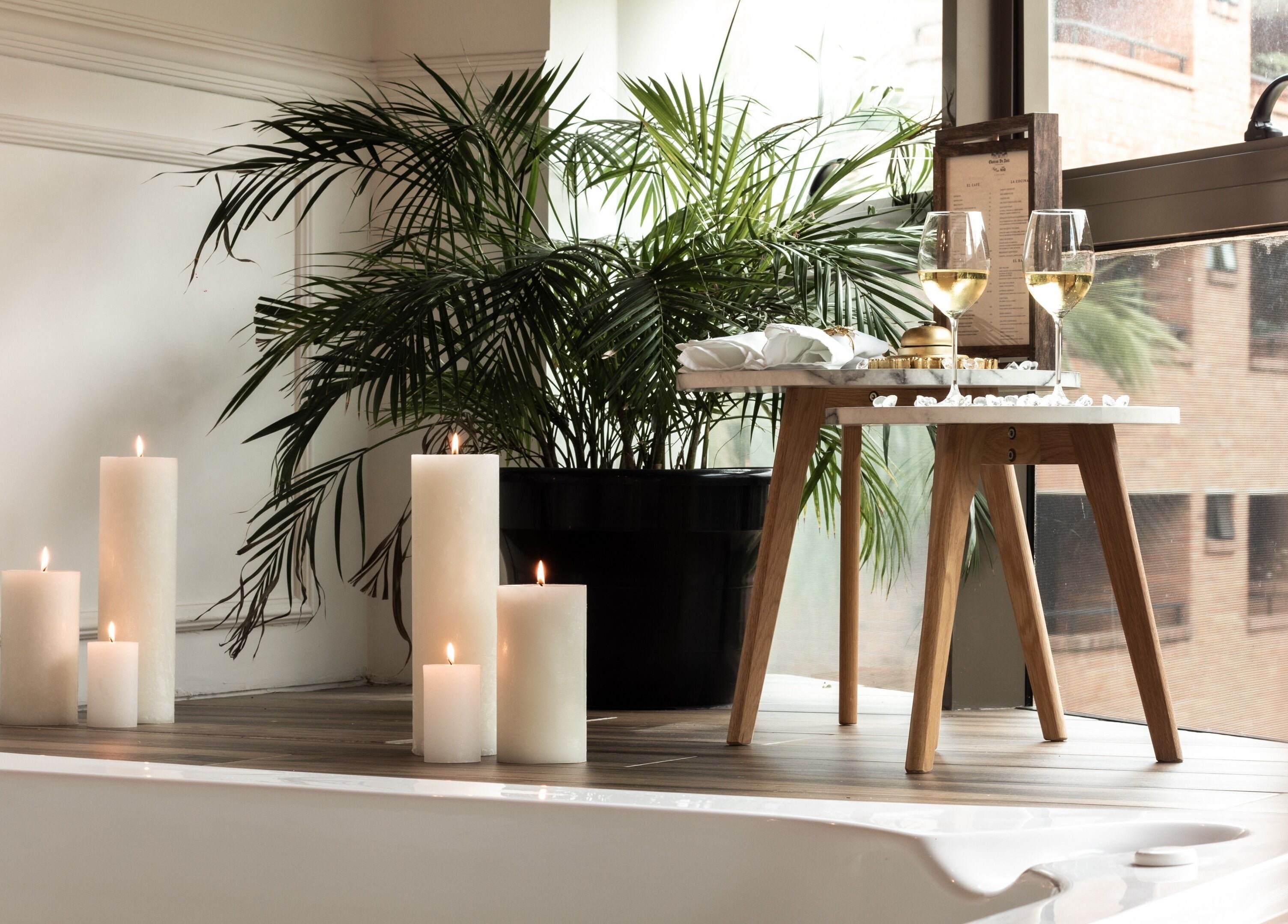 Le Spa Noir in Medellín, Antioquia, CO features a tranquil candlelit spa setting by a window.