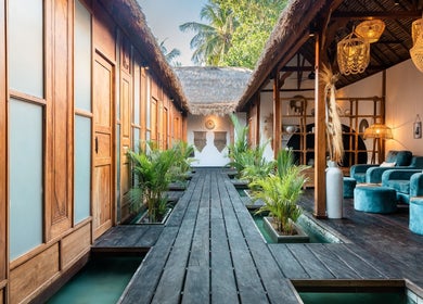 Relaxing interior of You Spa Gili Trawangan, Nusa Tenggara occidental, featuring lush greenery and cozy seating.