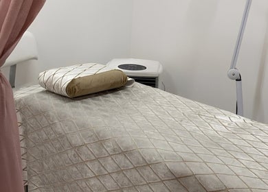 Lash Nook's serene treatment room in Cape Town, Western Cape, ZA, featuring a plush massage bed and pink curtain.