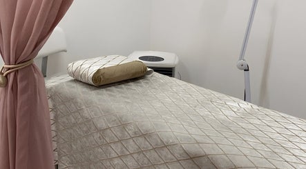 Lash Nook's serene treatment room in Cape Town, Western Cape, ZA, featuring a plush massage bed and pink curtain.