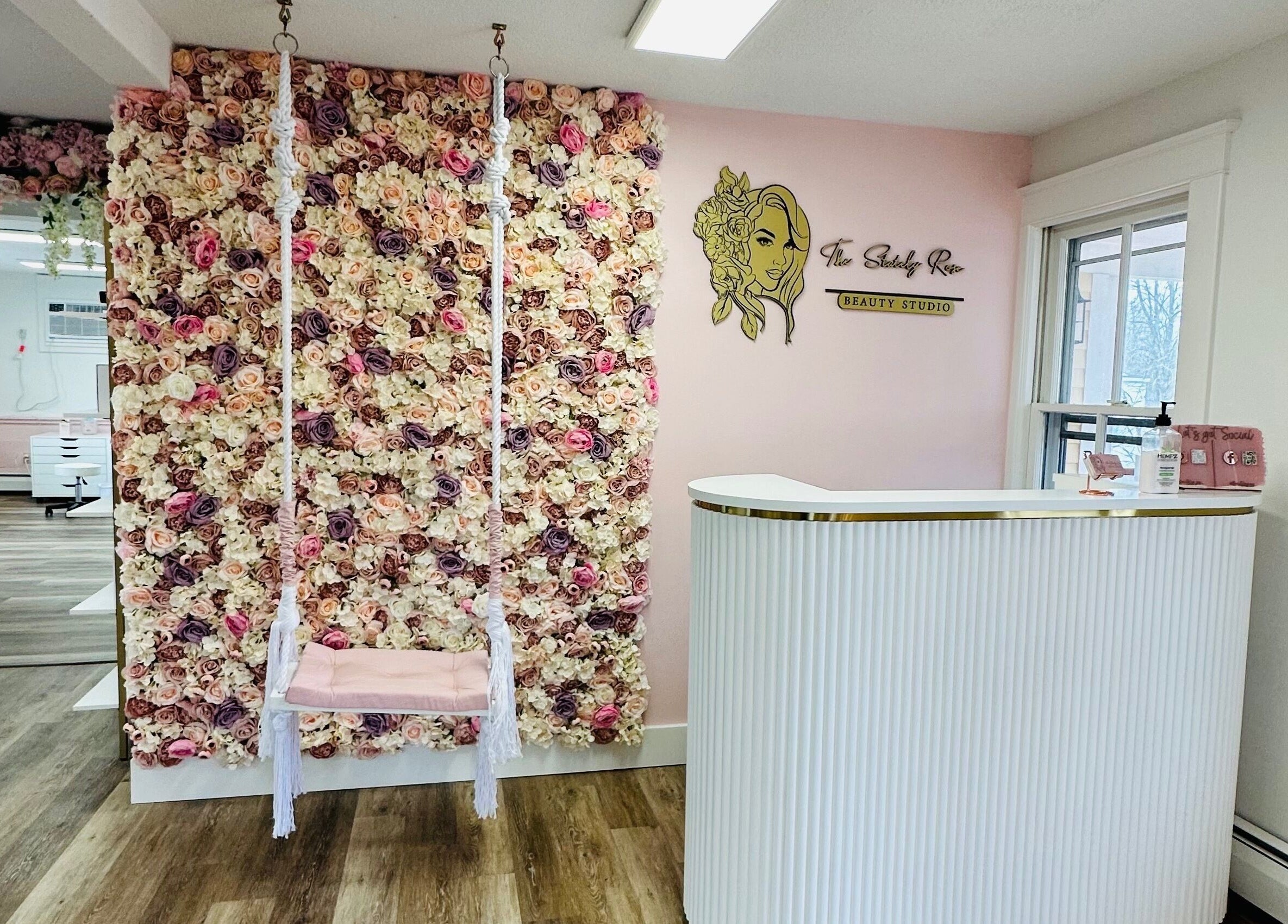 Entrance with floral wall and swing at The Stately Rose Beauty Studio in Avon, Connecticut, US.