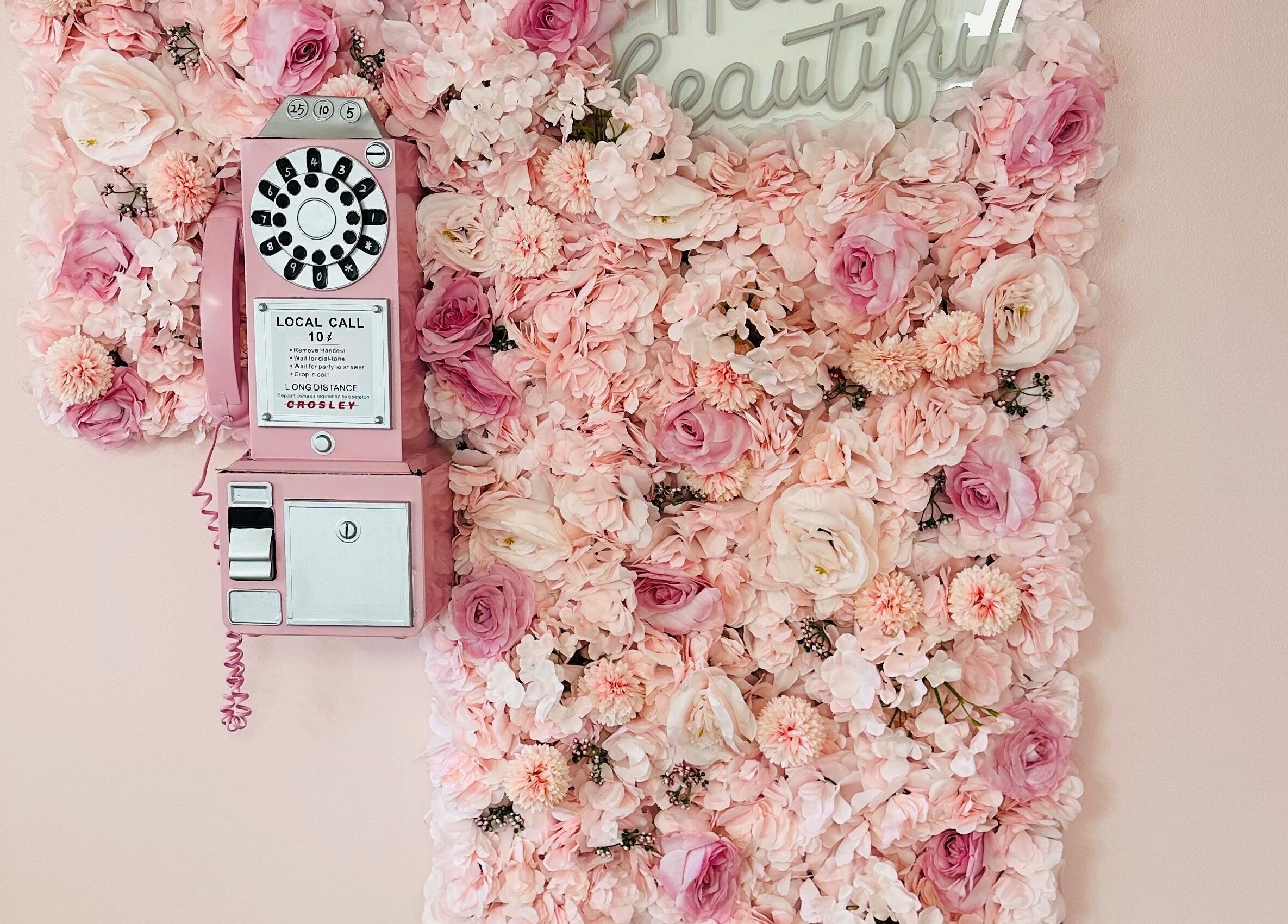 Pink rotary phone with floral backdrop at The Stately Rose Beauty Studio in Avon, Connecticut, US.