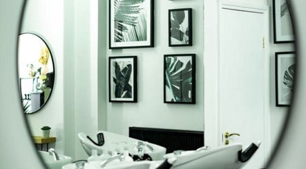 Stylish interior of R&R Organic Hair, London, England, GB, with chic decor and modern hair washing stations.