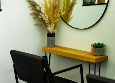 Elegant salon corner at R&R Organic Hair, London, England, GB with a wooden shelf and decorative plants.