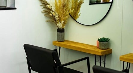 Elegant salon corner at R&R Organic Hair, London, England, GB with a wooden shelf and decorative plants.
