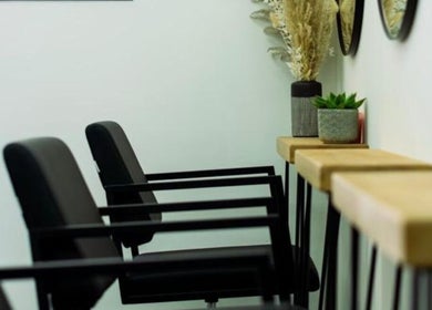 Stylish seating area at R&R Organic Hair, London, England, GB, with elegant black chairs and decor.