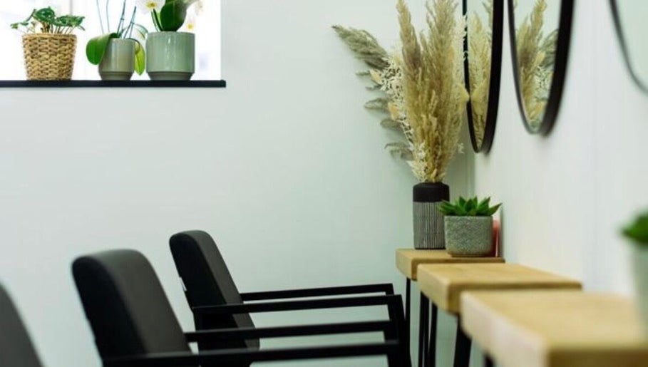 Modern salon seating at R&R Organic Hair, London, England, GB, with plant decor and mirrors enhancing ambiance.
